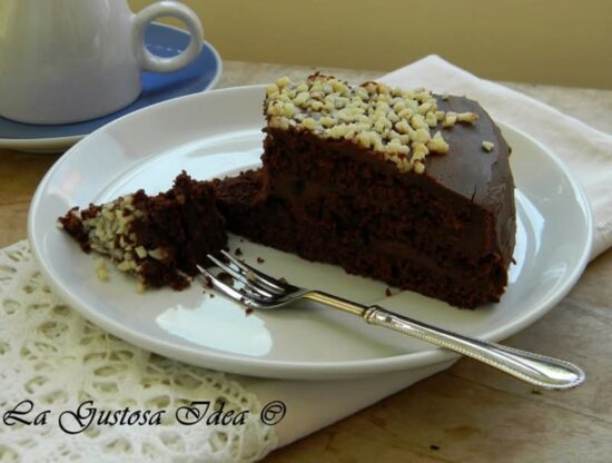 Fetta di torta al cacao con crema al cioccolato, ganache fondente e granella di nocciole